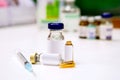 Sample vials and plastic syringe with 3 ml. ampule is opened on white table with ampule blurry background Royalty Free Stock Photo