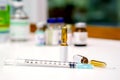 Sample vials and plastic syringe with 3 ml. ampule is opened on white table with ampule blurry background Royalty Free Stock Photo