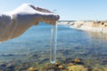 Sample water from the baltic sea for analysis. Hand in white glove holding a test tube