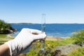 Sample water from the sea for analysis. Sea on background