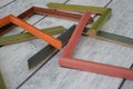 Samples of decorative wooden picture frames. Multi-colored frames for a baguette, randomly lying on a wooden light Royalty Free Stock Photo