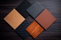 Samples of laminate and vinyl floor tile on black wooden background. Top view Royalty Free Stock Photo