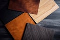 Samples of laminate and vinyl floor tile on black wooden background. Top view Royalty Free Stock Photo