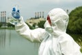 Sampling from open water. A scientist or biologist takes a water sample near an industrial plant. A sample of water in a Royalty Free Stock Photo