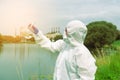 Sampling from open water. A scientist or biologist takes a water sample near an industrial plant. A sample of water in a Royalty Free Stock Photo