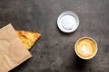 Samsa in paper envelope and cappuccino in paper cup on gray background top view