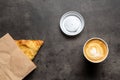 Samsa in paper envelope and cappuccino in paper cup on gray background top view