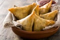 Samsa or samosas with meat and vegetables on wooden table. Traditional Indian food