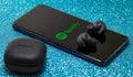Samsung Galaxy Buds 2 Pro and Spotify mobile application on smartphone screen