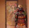 Samurai suit of armor standing next to Japanese painting
