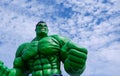 Low angle view of the large outdoor Hulk model display on roadside area against white cloudy in blue sky