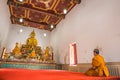 Monk pays respect to Buddha statues at Wat Yai Chom Prasat - Samut Sakhon, Thailand