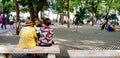 Samut Songkhram, Thailand - June 23, 2018: Old Asian women relaxing, talking and sitting beside on marble bench in park with green Royalty Free Stock Photo