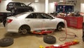 SAN ANTONIO, TX - NOVEMBER 23, 2016 - Car at Toyota dealer having tires and brakes replaced. the car is suspended. on red elevator