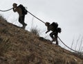 Firemen with hose climbing hill