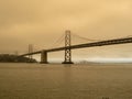 Bay Bridge surrounded by smog by nearby wildfires. Clean air can be seen in the distance at the Port of Oakland Royalty Free Stock Photo