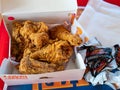 Popeyes Louisiana Chicken open box of chicken drumsticks and breast inside dinner special box next to ketchup and hot Royalty Free Stock Photo