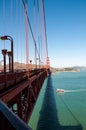 SAN FRANCISCO, CALIFORNIA - SEPTEMBER 8, 2015 - Golden Gate Bridge with pedestrians crossing and boat passing under Royalty Free Stock Photo