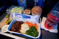 SAN FRANCISCO, CALIFORNIA, UNITED STATES - NOV 24th, 2018: Hot food served on board of economy class airplane on table