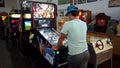 Man playing with a Star Wars themed pinball machine in an arcade salloon