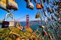 San Francisco iconic Golden Gate Bridge through opening in fence covered in locks