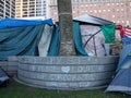Tents surround wall with the writing of Occupy SF, Peace, Love, Stop Corporate Greed in Chalk