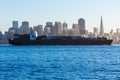 San francisco Skyline with merchant ship cruising bay at California