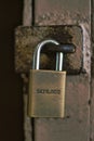 Schlage hardened weathered padlock holding a door closed Royalty Free Stock Photo