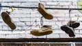 Close up of old sneakers and shoes hanging on a wire in front of an old building Royalty Free Stock Photo