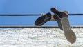 Old sneakers and shoes hanging on a wire Royalty Free Stock Photo