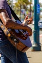 San Francisco, USA - July 15, 2019, male hands and fingers of a guitarist who touch the strings on a brown 6-string