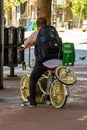 San Francisco, USA - July 6, 2019, a tourist cyclist with a backpack on his back sits on an unusual bicycle on a street of the