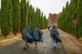 San Galgano, Chiusdino, Italy. August 2020. Conceptual image of meteorological variability: a group of tourists try to protect
