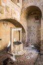 SAN GIMIGNANO, ITALY - OCTOBER 8, 2018: Medieval stone well and old frescoes on the walls in the courtyard of Civil Museum