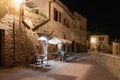 San Gimignano, Tuscany, Italy. August 2020. Picturesque night view on one of the streets of the historic center with the tables of