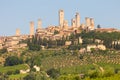 San Gimignano village, Italy: green countryside, blue sky, hill panorama with town and towers