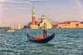 San Giorgio Maggiore and a gondolier on a gondola, view from the sea, Venice, Italy