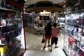 Customers pass by rows of toy stores and a snack bar inside a commercial shopping center