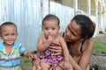 Woman beggar with boils cuddling daughter at church yard