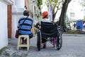 Lady, Blind Man beside disabled Beggar in wheelchair at Church yard Gate Portal to seek alms