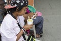 Wheelchair female Beggar holding a cup of gruel