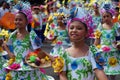 Girl carnival dancers in various costumes dance along the road