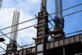 Filipino construction steel-men working joining column steel pieces on board scaffolding pipes on high-rise building