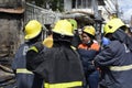 Local firewoman man help on emergency response rescue during house fire that gutted interior shanty houses