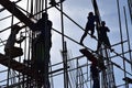 A group of Filipino Construction steel workers assembling steel bars on high-rise building with no proper protective suits and saf