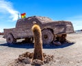 Car sculpture, San Pedro Cactus and Bolivian Flag in salt flat Salar de Uyuni, Bolivia Royalty Free Stock Photo