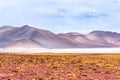 Beautiful landscape with desertic field, frozen lagoon and snowy mountains in Atacama Royalty Free Stock Photo