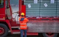 Truck driver secures the loading of bottles of mineral water by binding it with ropes before starting the transport