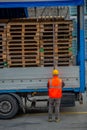 Truck driver secures the loading of bottles of mineral water by binding it with ropes before starting the transport