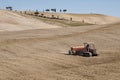 SAN QUIRICO D`ORCIA, TUSCANY / ITALY - OCTOBER 31, 2016: Undefined man on a tractor in the beautiful tuscan landscape